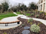 Landscaped flowerbeds, paths and curved benched in the community garden at Mountbatten View