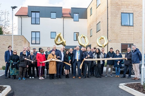 Residents, councillors, members of our Housing team and representatives from Bugler Developments cutting a ribbon to celebrate our 400th council home