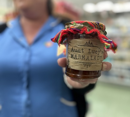 Pharmacy employee holding a jar of Aunt Lucy' marmalade