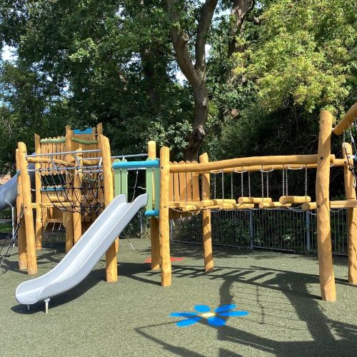 Wooden play equipment including slide and climbing frame