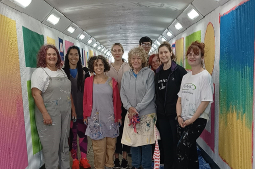 Mural artists standing in the underpass beneath the Plough Roundabout